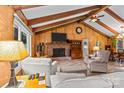 Relaxing living room featuring wood paneled walls, vaulted ceiling, a brick fireplace, and neutral furniture at 143 Bostian Lake Rd, Statesville, NC 28677