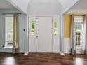 Inviting foyer featuring wood floors, a white front door, and windows for natural light at 14520 Cardamon Ct, Charlotte, NC 28273