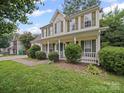 Two-story home with a charming front porch and lush green lawn, perfect for suburban living at 14520 Cardamon Ct, Charlotte, NC 28273