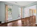 Open living room showcasing hardwood floors and large windows, filling the space with natural light at 14520 Cardamon Ct, Charlotte, NC 28273