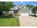 Charming two-story home featuring stone accents, a well-manicured lawn, and a two-car garage at 1677 Shetland Ln, Rock Hill, SC 29730