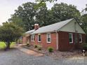 A well-kept red brick home with a lovely yard and lush landscaping; a serene and inviting setting at 180 Tower Rd, Troy, NC 27371