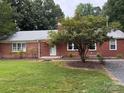Charming one-story red brick home with a well-manicured lawn and mature landscaping in a serene setting at 180 Tower Rd, Troy, NC 27371