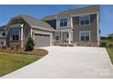 Attractive home with stone facade, gray siding, two-car garage, and long concrete driveway at 2084 Fordhill St, Rock Hill, SC 29732