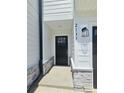 Modern front door with black hardware, stone accents, and a contemporary light fixture with house numbers at 2137 Barrowcliffe Dr # 49, Concord, NC 28027