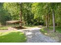 Gravel driveway and covered parking area surrounded by mature trees and landscaping at 2615 Highway 557 None, Clover, SC 29710