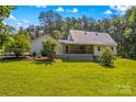 Backyard features a spacious lawn and a covered porch perfect for relaxing and entertaining at 265 River Run Rd, Statesville, NC 28625