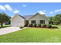 Single Gathering home featuring a well-manicured lawn, mulched flower beds, and a two car garage at 2906 Plantation Way, Albemarle, NC 28001