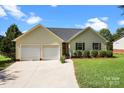 Single Gathering home featuring a well-manicured lawn and a two car garage on a sunny day at 2906 Plantation Way, Albemarle, NC 28001