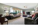 Comfortable living room with large windows, neutral colors, and a ceiling fan at 29636 Lakeside Dr, Albemarle, NC 28001