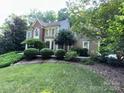Charming two-story home featuring a combination of siding and brick accents, complemented by mature trees and landscaping at 5024 Ardenwoods Dr, Charlotte, NC 28215