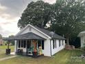 Quaint house with covered porch and attractive outdoor seating in lush, green yard at 508 E Rice St, Landis, NC 28088