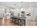 Bright kitchen with a gray kitchen island, modern stainless appliances, and wood-style floors at 5240 Hatcher Creek Rd # 51, Charlotte, NC 28215