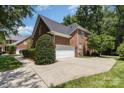 Side view of a beautiful brick home with a two-car garage and a well-maintained lawn at 6612 Saunton Ct, Charlotte, NC 28277