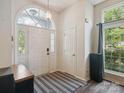 Inviting foyer with a striking front door, large window, wood flooring, and modern light fixture at 8323 Bedford Green Ln, Charlotte, NC 28215