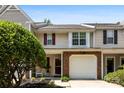 Charming townhouse with brick accents, a one-car garage, and well-maintained landscaping at 9977 Reindeer Way Ln, Charlotte, NC 28216
