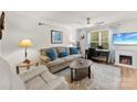 Bright living room with hardwood floors, a cozy fireplace, and a dedicated workspace at 9977 Reindeer Way Ln, Charlotte, NC 28216