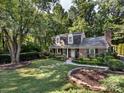 Landscaped front lawn and a brick home nestled amongst mature trees at 101 Treeline Dr, Belmont, NC 28012