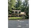 Traditional two-story home with neutral siding, dormer windows, front yard, and mature trees at 101 Treeline Dr, Belmont, NC 28012