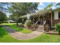 Charming front porch features a 'Welcome' sign, inviting steps, and decorative landscaping around the walkway at 1104 Pump Station Rd, Kannapolis, NC 28081