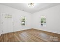 Bright living room with two windows, white walls and modern flooring at 1108 4Th St, Statesville, NC 28677