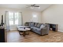 Bright living room featuring vaulted ceilings, wood-look floors, and a comfortable sectional sofa at 118 Cypress Acres Ln, Statesville, NC 28625