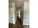 This hallway has wooden floor, white walls, doors and ceiling lights at 1411 Cottage Green Dr # 218, Monroe, NC 28112
