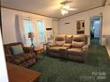 Comfortable living room featuring a plush, reclining sofa, window with curtains, and an open floorplan at 16711 Indian Mound Rd, Albemarle, NC 28001