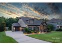 Beautiful home exterior featuring a three-car garage, stone accents, and manicured landscaping at 2009 Freeport Dr, Indian Trail, NC 28079