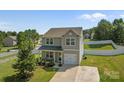 Charming two-story home with gray siding, attached garage, and a cozy front porch with lush landscaping at 2301 Amesbury Ct, Albemarle, NC 28001