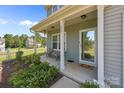 Inviting front porch with seating, decorative plants, and a clear view through the glass front door at 2301 Amesbury Ct, Albemarle, NC 28001
