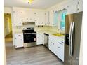 White kitchen with stainless steel appliances and laminate flooring at 2660 Tiffany St, Conover, NC 28613