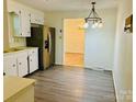 Kitchen with white cabinets, stainless steel refrigerator, and laminate flooring at 2660 Tiffany St, Conover, NC 28613