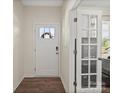 Bright foyer featuring wood floors, white trim, and a glass paneled office doorway at 404 Saddlebred Ln, Locust, NC 28097