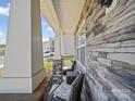 Inviting porch features stacked stone accents, comfortable seating, and charming architectural details for relaxation at 404 Saddlebred Ln, Locust, NC 28097