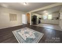 Open concept living room boasts dark hardwood floors with bright light from the kitchen at 608 E 11Th St, Newton, NC 28658
