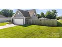 Fenced backyard features green grass and access to a two car garage at 6401 Morehead Rd, Harrisburg, NC 28075