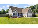 Charming home with blue shutters, a well-maintained lawn, and a two-car garage at 6401 Morehead Rd, Harrisburg, NC 28075