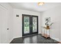 Inviting foyer with decorative double doors, stone tile flooring, and modern accents at 7107 Cedarfield Rd, Charlotte, NC 28227