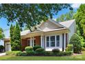 Close-up of a well-maintained home with brick accents, columns, and manicured bushes at 8712 Soaring Eagle Ln, Waxhaw, NC 28173