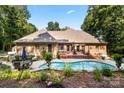 Gorgeous backyard featuring a sparkling pool, hot tub, and outdoor seating area at 107 Creekwood Dr, Dallas, NC 28034