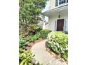 Inviting walkway leading to the front door, surrounded by lush landscaping and vibrant flowers at 10825 Traders Ct, Davidson, NC 28036