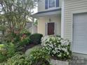 Inviting walkway leading to the front door, surrounded by lush landscaping and vibrant flowers at 10825 Traders Ct, Davidson, NC 28036