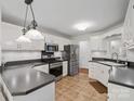 Bright kitchen with stainless steel appliances, white cabinetry, and tile flooring; functional and stylish design at 132 General Pemberton St, Stanley, NC 28164