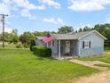 Inviting single-story home with a cozy front porch featuring rocking chairs and an American flag at 151 Robinson Rd, Gastonia, NC 28056