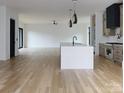 Open-concept kitchen with a large island, stainless appliances, and hardwood floors at 1511 Waverly Ave, Charlotte, NC 28203