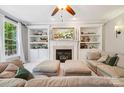 Comfortable living room with a fireplace, flanked by custom built-in shelving at 15620 Glen Miro Dr, Huntersville, NC 28078
