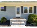 Close-up of a light blue brick home with a white front door and freshly landscaped yard at 203 Nottingham Dr, York, SC 29745