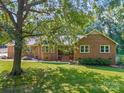 All brick home featuring lush green lawn and mature trees, offers charm and curb appeal at 229 Campsite Rd, Rock Hill, SC 29732