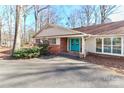 Inviting front entrance featuring a bright blue double door, brick accents and mature shrubbery at 251 Gleneagles E Rd, Statesville, NC 28625